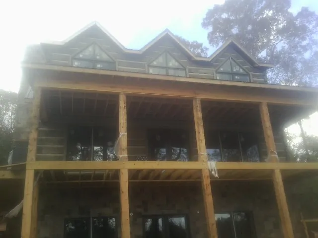 Dormers and porch framing on a large log home under construction — Roof Coating work by our crew in Circleville